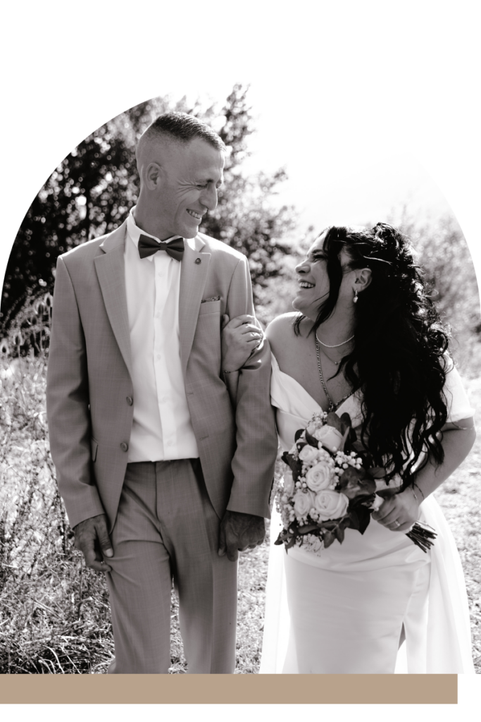 Mariés dans un champ, rires, robe blanche, bouquet, costume, lumière d'été